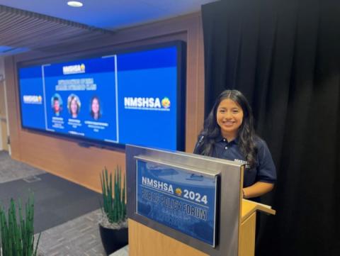 Berenice Verdugo standing at a podium.